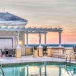 hotel italiani più belli del mondo. piscina sul tetto al tramonto, con sedie attorno e veranda.