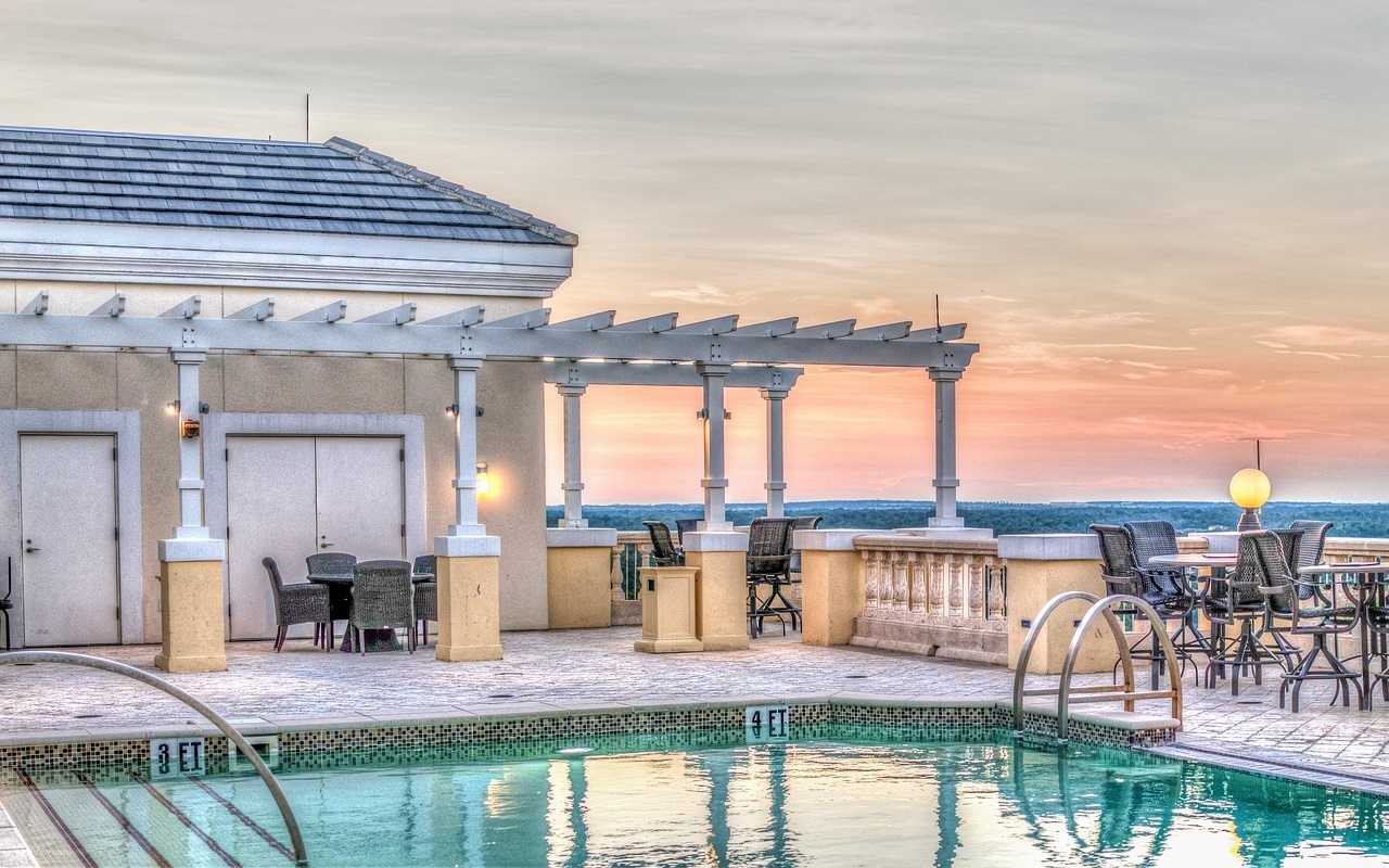 hotel italiani più belli del mondo. piscina sul tetto al tramonto, con sedie attorno e veranda.
