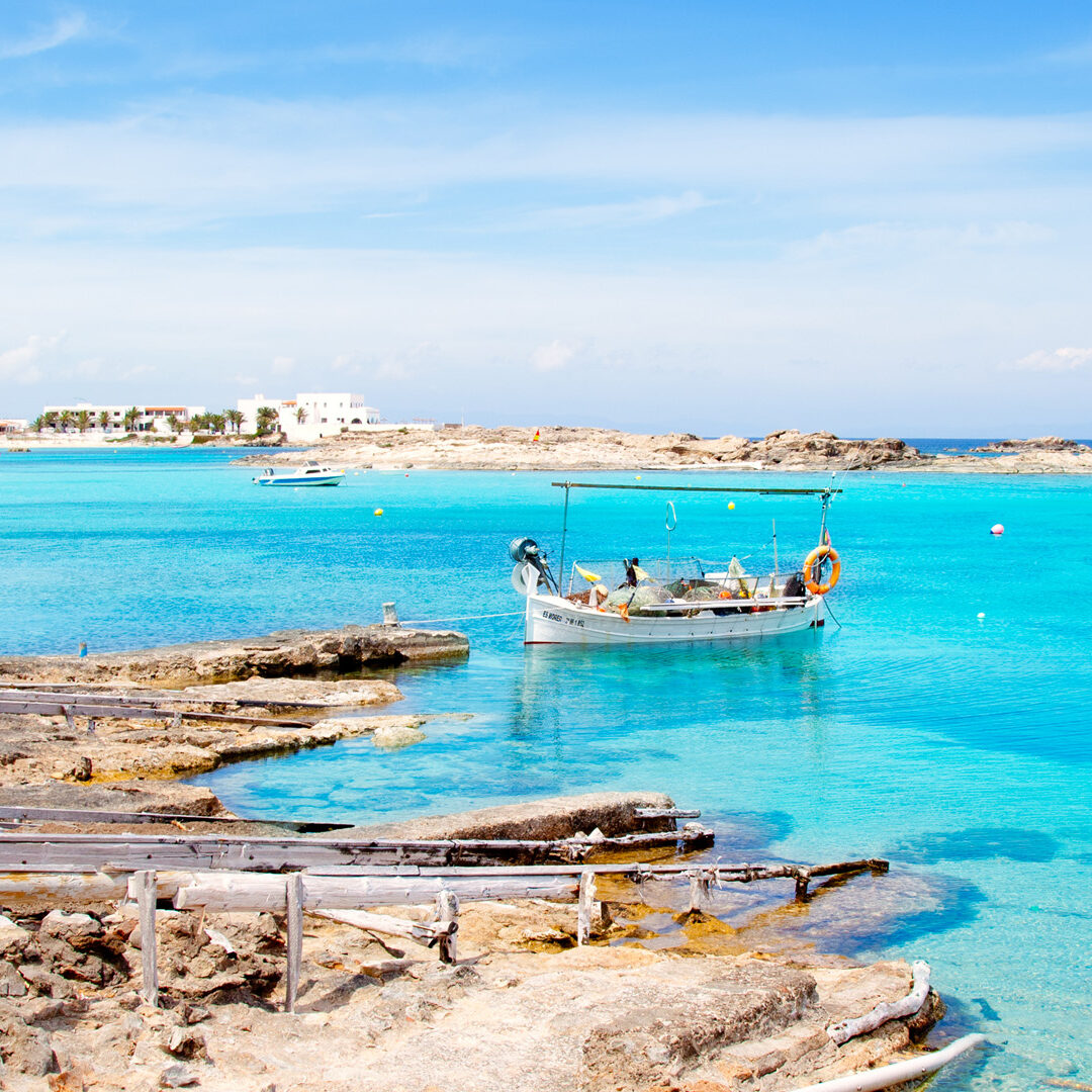 Els Pujols beach in Formentera with traditional fishing boat in summer day