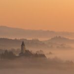 Croazia: tra natura e divertimento. Vista di una chiesa in lontananza, avvolta dalla nebbia.