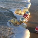 Vendite aperte Natale e Capodanno 2022/2023. Palle di natale in riva al mare.