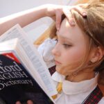 l'inglese da viaggio. ragazza che legge il dizionario d'inglese