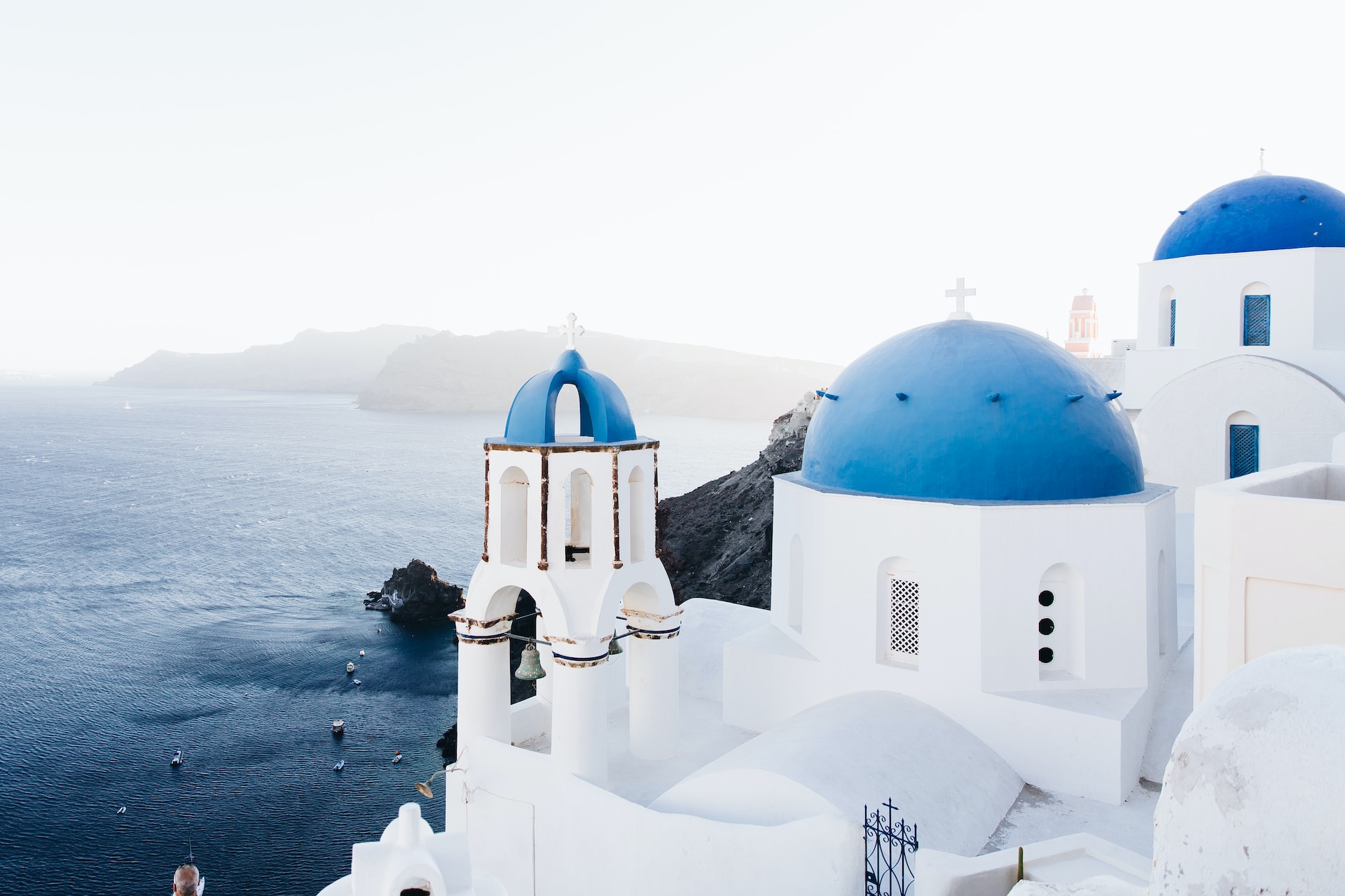 Dove andare in Grecia 2023. Tetti blu e case bianche sul mare viste dall'alto.