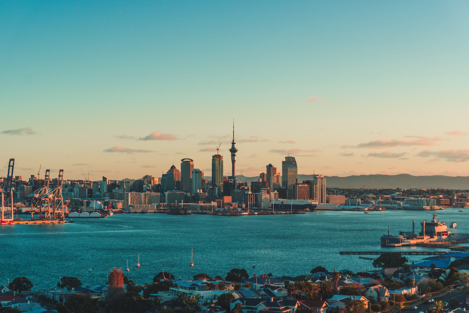 Viaggio in Nuova Zelanda 2024. Vista su Auckland e l'oceano da lontano con cielo rosa al tramonto.